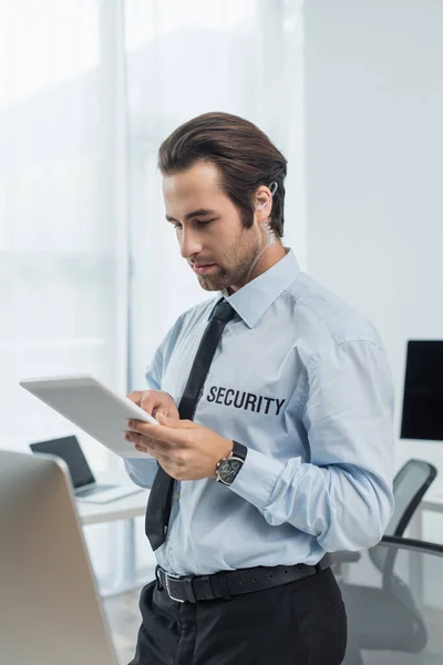 Protège-oreilles et chemise avec lettrage de sécurité à l'aide d'une tablette numérique au bureau — Photo de stock