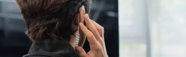 Back view of security man adjusting earphone, banner — Stock Photo