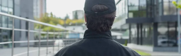 Vue arrière de l'homme de sécurité en uniforme noir sur la rue urbaine, bannière — Photo de stock