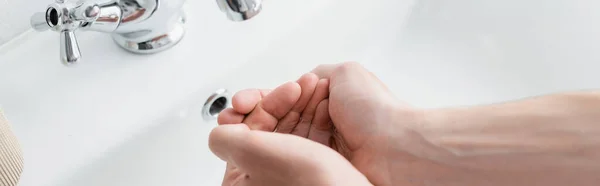 Обрізаний вид людини миє руки у ванній кімнаті, банер — стокове фото