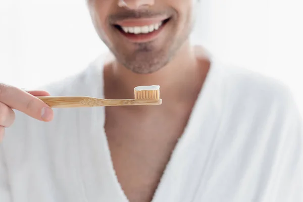 Vista cortada de homem sorrindo borrado segurando escova de dentes com pasta de dentes — Fotografia de Stock