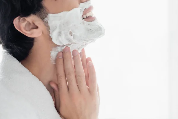 Vue recadrée du jeune homme souriant appliquant de la mousse à raser — Photo de stock