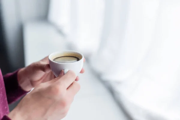 Vista cortada do homem segurando xícara de café em casa — Fotografia de Stock