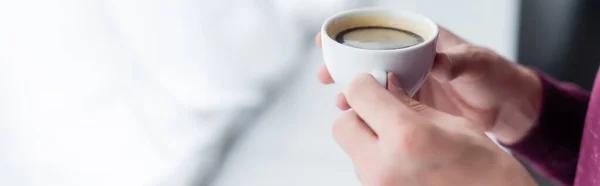 Vista parcial del hombre sosteniendo la taza de café en casa, pancarta - foto de stock