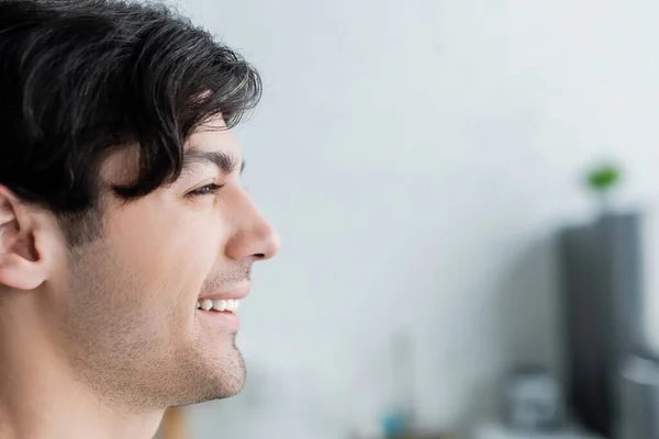 Profile of happy brunette man on blurred background — Stock Photo