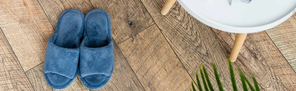 Vue du dessus des pantoufles bleues sur le sol en bois dans la chambre, bannière — Photo de stock
