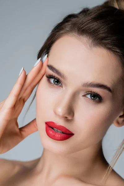 Closed up view of charming woman with perfect skin and makeup looking at camera isolated on grey — Stock Photo