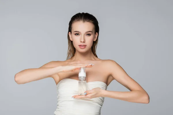 Young woman in strapless top holding face foam isolated on grey — Stock Photo