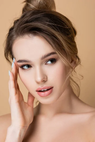 Vista de cerca de la mujer bonita con la piel perfecta y maquillaje natural aislado en beige - foto de stock