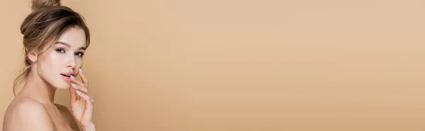 Donna affascinante con spalle nude guardando la fotocamera isolata sul beige, banner — Foto stock