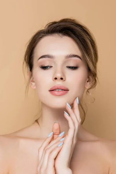 Mujer joven y sensual con piel perfecta y maquillaje natural aislado en beige - foto de stock