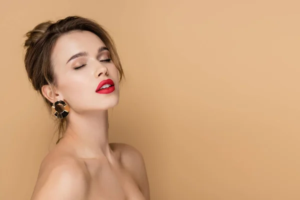 Charming woman with bare shoulders and closed eyes isolated on beige — Stock Photo