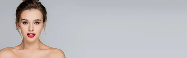 Jovem e bonita mulher com ombros nus e maquiagem isolada em cinza, banner — Fotografia de Stock