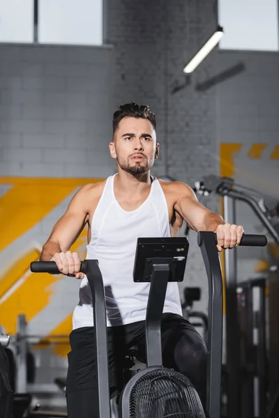 Sportsman training on elliptical trainer in gym — Stock Photo