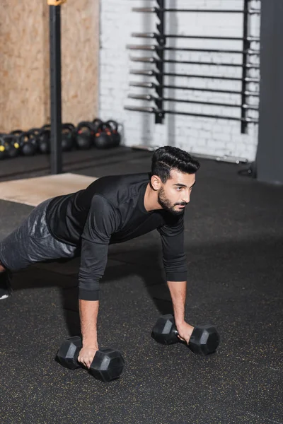 Hombre musulmán haciendo ejercicio con pesas en el gimnasio - foto de stock