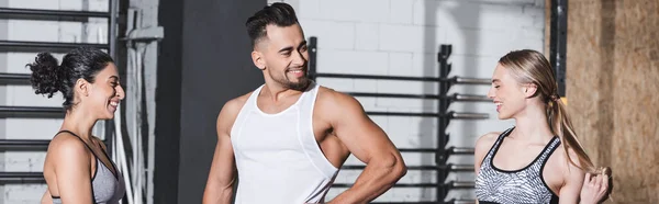 Smiling interracial sportives debout près sportif sportif dans la salle de gym, bannière — Photo de stock