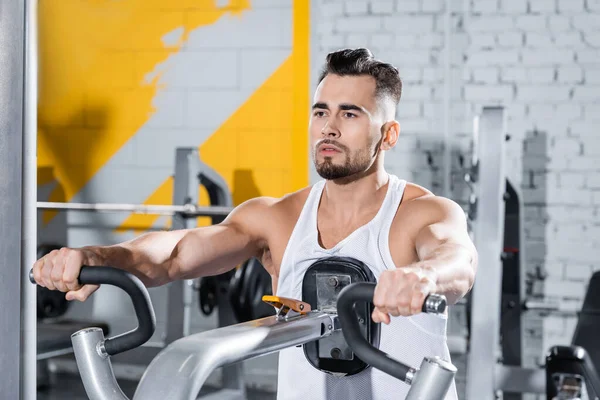 Sportsman training on ab crunch machine in sports center — Stock Photo