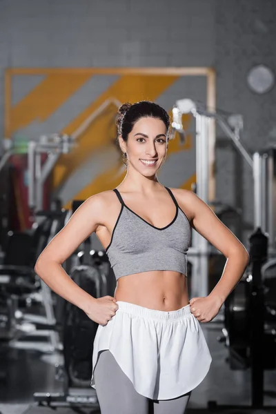 Sonriente deportista de Oriente Medio mirando a la cámara en el gimnasio - foto de stock