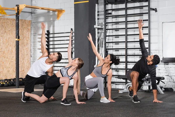 Interracial people stretching in sports center — Stock Photo