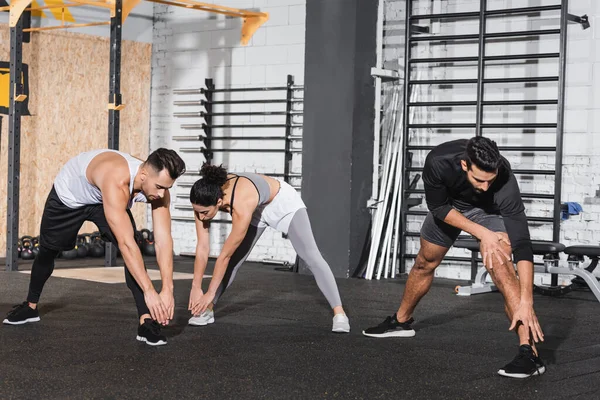 Interracial people warming up in sports center — Stock Photo