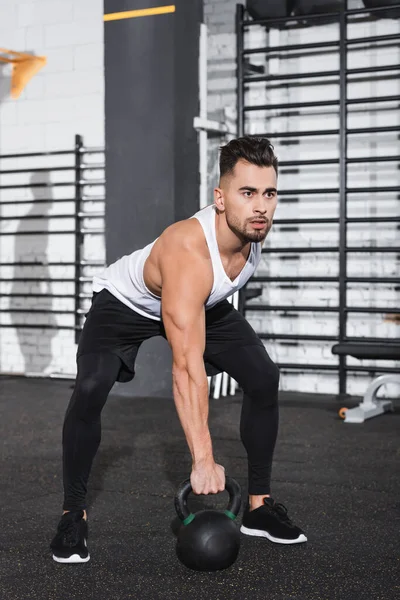 Sportler hält Kettlebell im Sportzentrum — Stockfoto