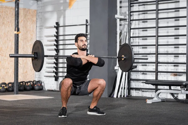 Arabe sportif levant haltère dans la salle de gym — Photo de stock