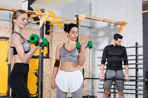 Multiethnische Sportlerinnen trainieren mit Kurzhanteln im Fitnessstudio — Stockfoto