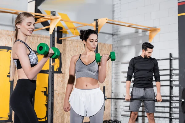 Des sportives multiethniques s'entraînent avec des haltères dans un gymnase — Photo de stock