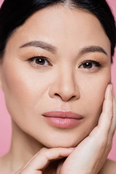 Close up view of asian woman touching face isolated on pink — Stock Photo