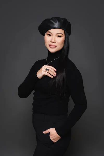 Élégant asiatique femme en béret posant isolé sur gris foncé — Photo de stock