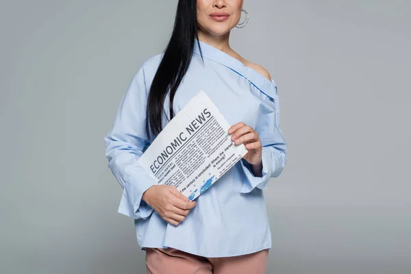 Cropped view of stylish woman holding economic newspaper isolated on grey — Stock Photo