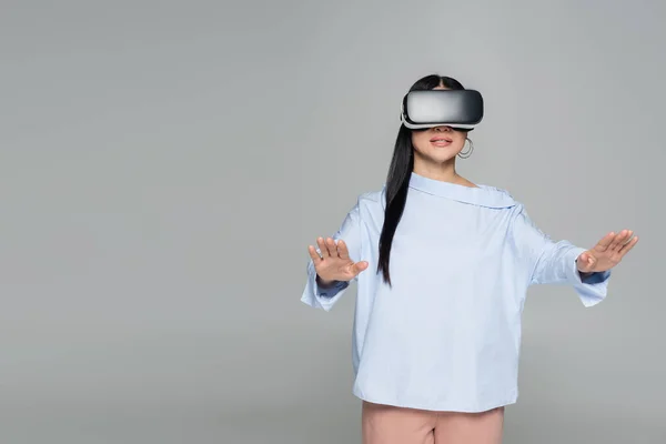 Donna in auricolare vr giocare video gioco isolato su grigio — Foto stock