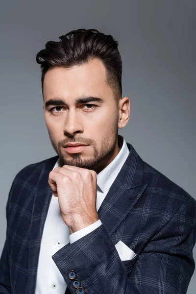 Hombre de negocios barbudo en chaqueta a cuadros mirando a la cámara aislada en gris — Stock Photo