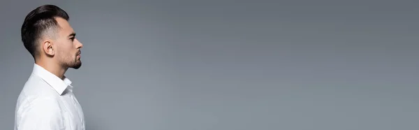 Vista lateral del hombre de negocios barbudo en camisa blanca aislada en gris, bandera — Stock Photo