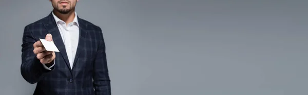 Vista ritagliata di uomo d'affari in giacca dando carta bianca isolato su grigio, banner — Foto stock