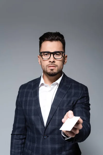 Businessman in glasses and blazer offering blank card isolated on grey — Stock Photo