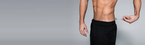 Vista cortada de desportista sem camisa e muscular injetando-se nas costas em cinza, banner — Fotografia de Stock