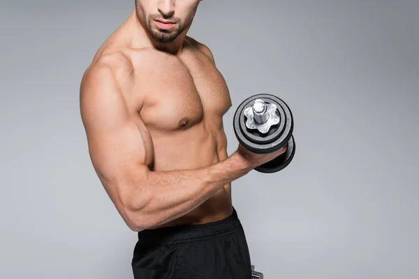 Teilbild eines starken bärtigen Mannes, der mit einer Hantel isoliert auf grau trainiert — Stockfoto