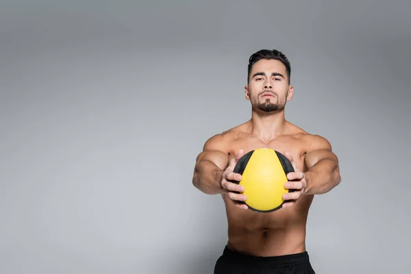 Без рубашки и бородатый спортсмен держит мяч на сером — стоковое фото