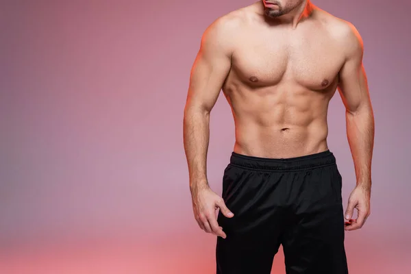 Vista cortada do homem sem camisa com os músculos posando em rosa e cinza — Fotografia de Stock