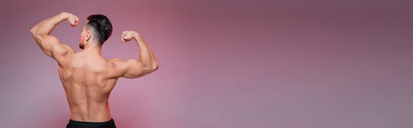 Back view of strong sportsman showing muscles on pink and grey, banner — Stock Photo