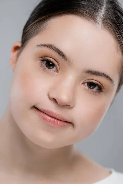 Portrait of woman with down syndrome looking at camera isolated on grey — Stock Photo