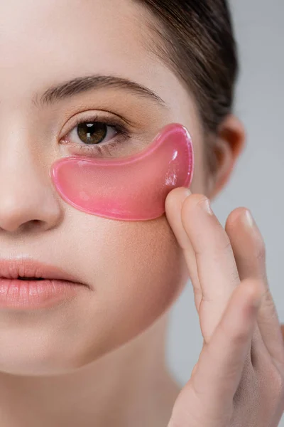 Cropped view of woman with down syndrome applying eye patch isolated on grey — Stock Photo