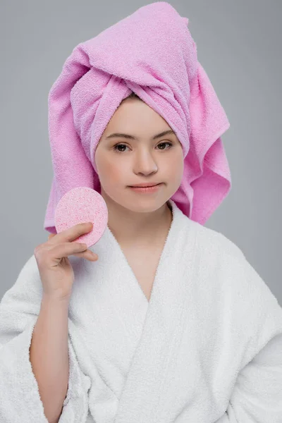 Woman with down syndrome in bathrobe holding sponge isolated on grey — Stock Photo