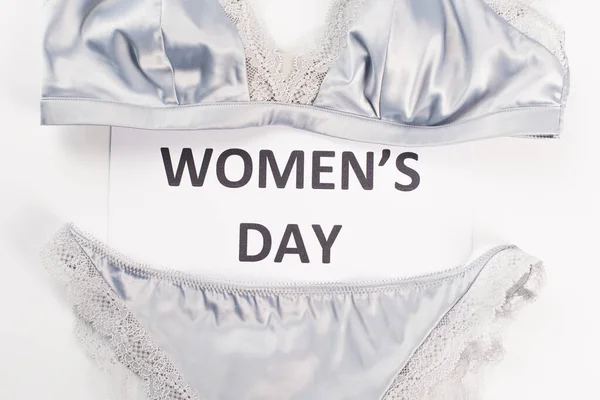 Top view of card with womens day lettering near lingerie on white background — Stock Photo