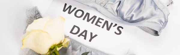 Draufsicht auf Dessous in der Nähe Karte mit Women Day Schriftzug und Rose auf weißem Hintergrund, Banner — Stockfoto