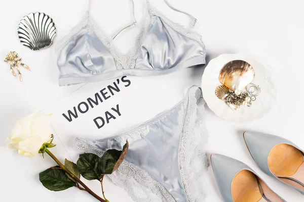 Top view of lingerie, card with womens day lettering and heels on white background — Stock Photo