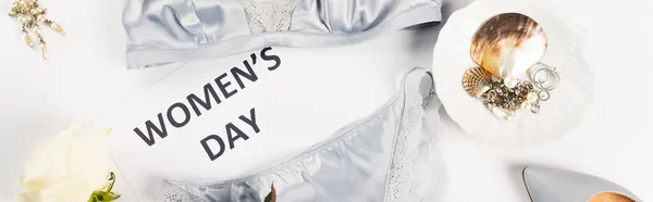 Top view of accessories near lingerie and card with womens day lettering on white background, banner — Stock Photo