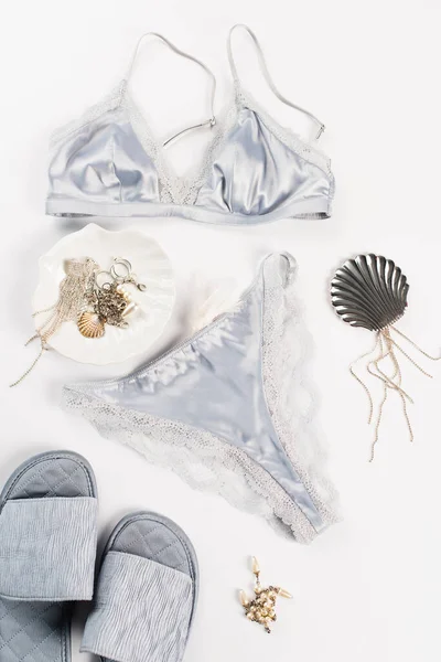 Vista dall'alto di pantofole vicino lingerie e accessori su sfondo bianco — Foto stock