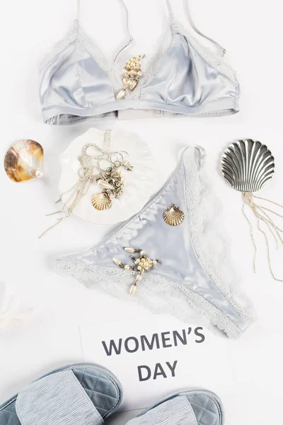 Top view of lace underwear near slippers, accessories and card with womens day lettering on white background — Stock Photo